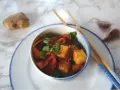 Pyszne dania z tofu z marchewką i szczypiorkiem, gotowe do jedzenia pałeczkami. Obok imbir i czosnek.
