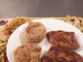 Kotlety sojowe na talerzu i surowe kawałki soi na desce.