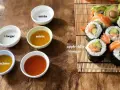 Szukasz alternatywy dla octu ryżowego? Na stole widzisz sushi, jabłkowy ocet, mirin, sok z cytryny i ocet.