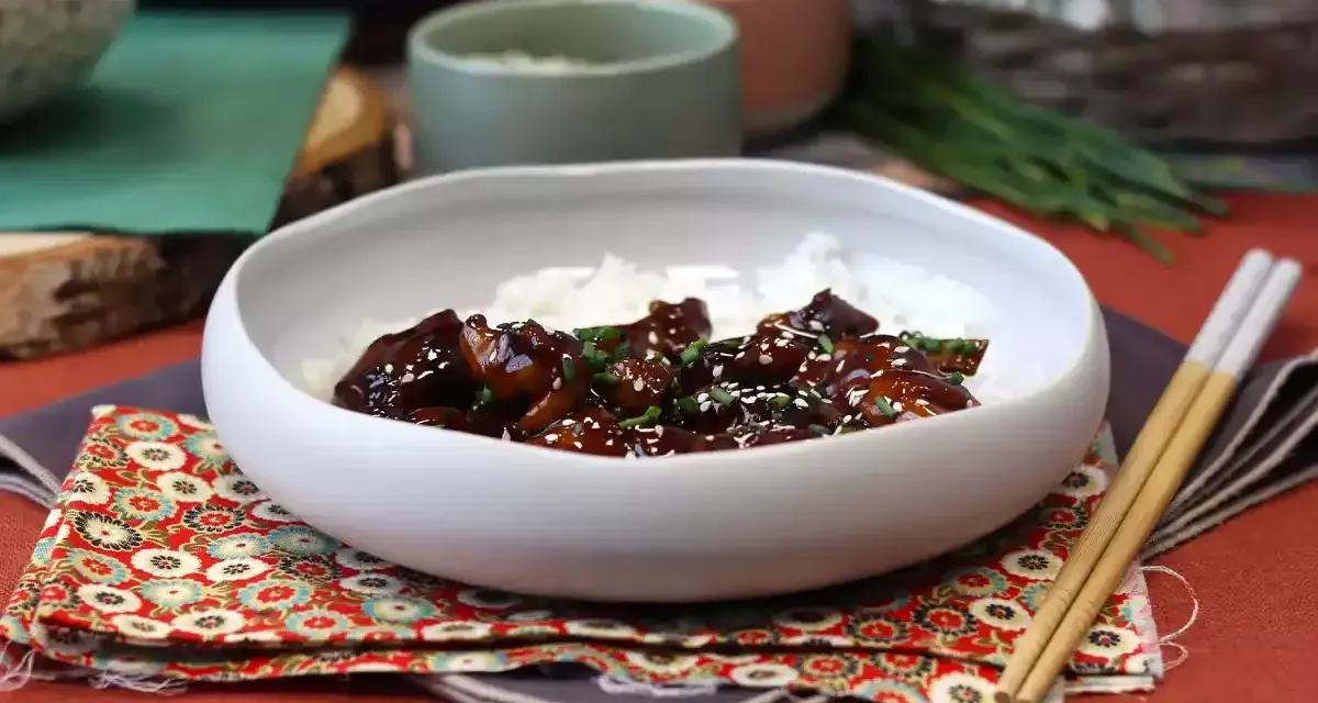 Pyszny kurczak po japońsku w sosie teriyaki, podany z ryżem i posypany sezamem.
