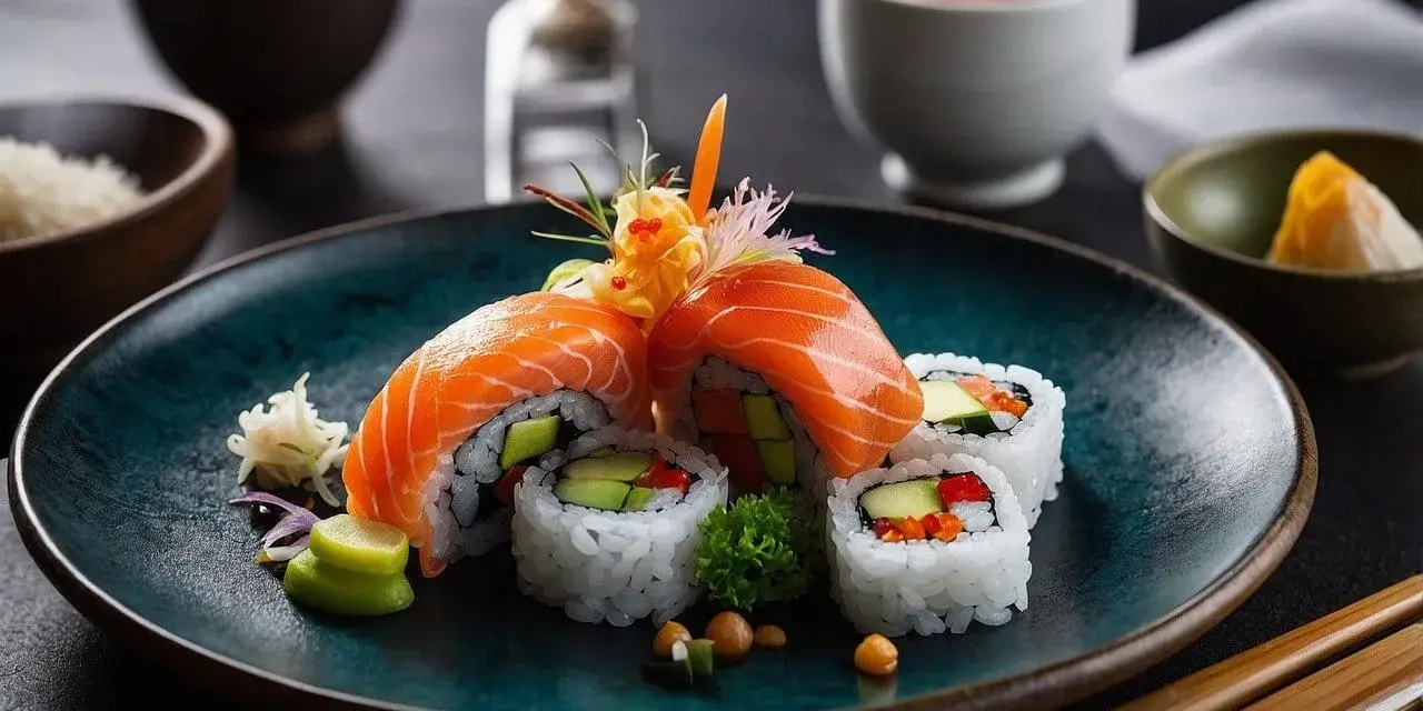 Talerz z kolorowymi rolkami sushi z łososiem, awokado i warzywami, udekorowany imbirem i wasabi.