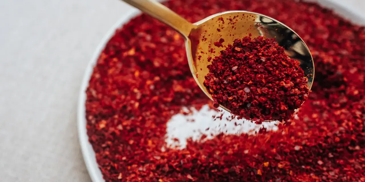 Złota łyżka nabiera gochugaru, koreańskich płatków chili. To właśnie gochugaru co to za przyprawa?
