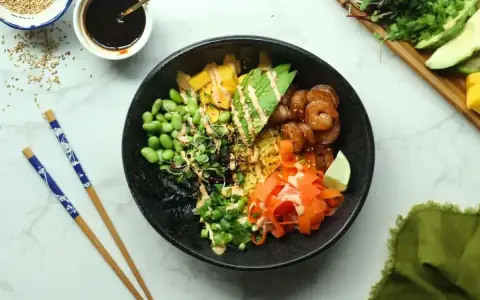 Kolorowy poke bowl z krewetkami, awokado, edamame i marchewką. Idealny przepis na szybki i zdrowy posiłek.