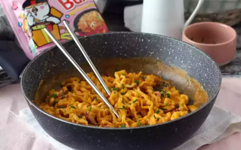 Pikantny buldak carbonara w patelni, gotowy do jedzenia.