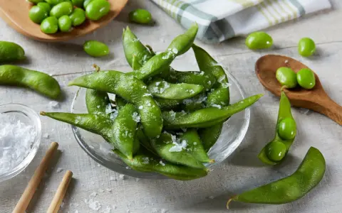 Misternie ułożone strąki edamame, posypane solą, kuszą swoim zielonym kolorem. Czy wiesz, edamame co to? To młoda soja, pyszna przekąska!