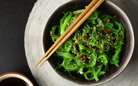 Sałatka z wodorostów wakame, posypana sezamem i chili. Zastanawiasz się wakame co to? To pyszna, zdrowa przekąska.