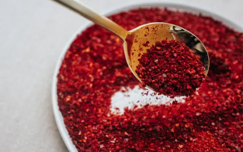 Złota łyżka nabiera gochugaru, koreańskich płatków chili. To właśnie gochugaru co to za przyprawa?