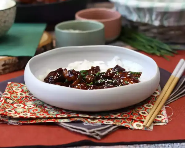 Pyszny kurczak po japońsku w sosie teriyaki, podany z ryżem i posypany sezamem.