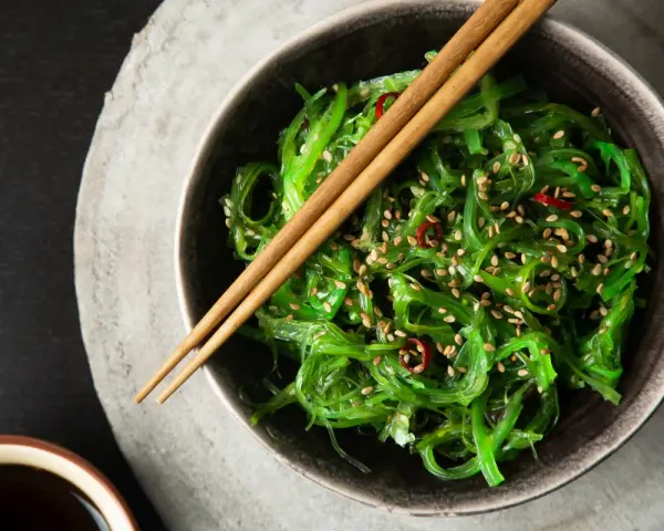 Sałatka z wodorostów wakame, posypana sezamem i chili. Zastanawiasz się wakame co to? To pyszna, zdrowa przekąska.