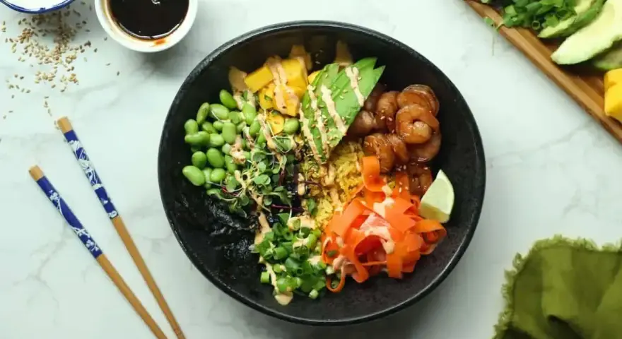 Kolorowy poke bowl z krewetkami, awokado, edamame i marchewką. Idealny przepis na szybki i zdrowy posiłek.