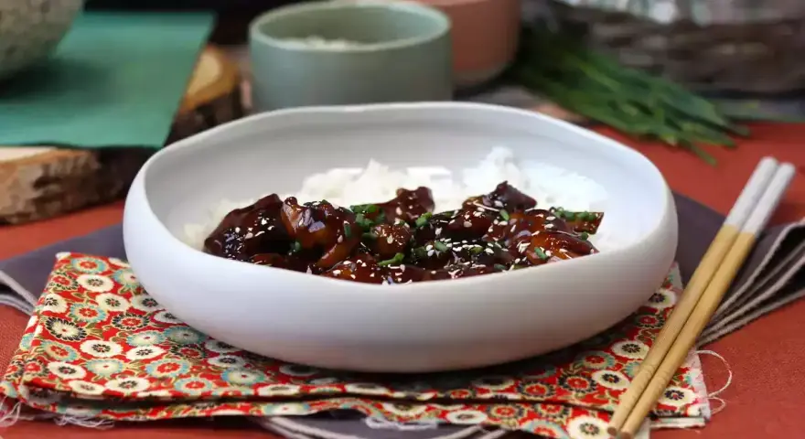 Pyszny kurczak po japońsku w sosie teriyaki, podany z ryżem i posypany sezamem.