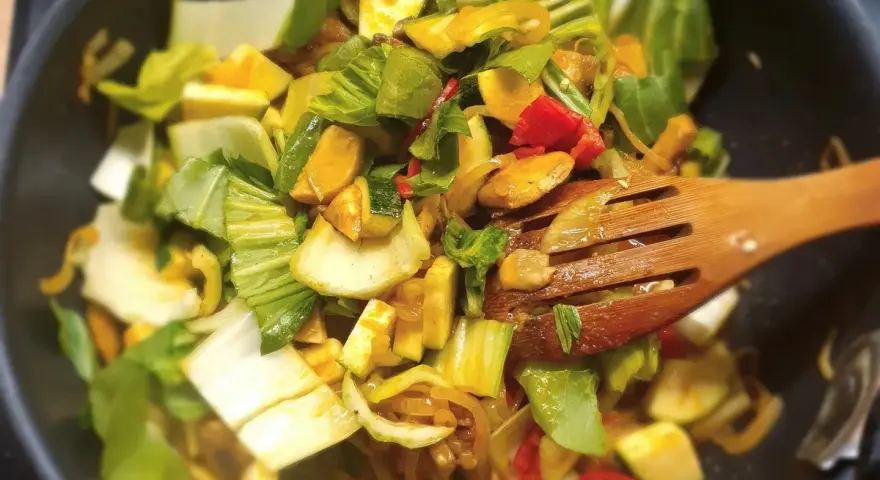Kolorowe warzywa, w tym kapusta pak choi, smażone na patelni. Idealne do szybkich i zdrowych dań, inspiracja do kapusta pak choi przepisy.
