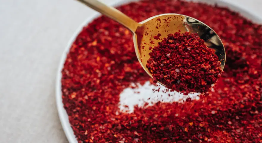 Złota łyżka nabiera gochugaru, koreańskich płatków chili. To właśnie gochugaru co to za przyprawa?
