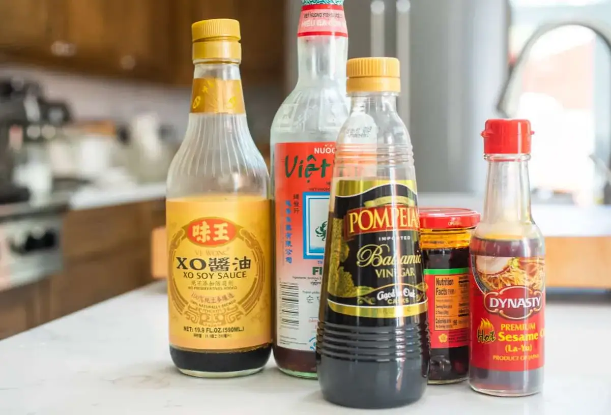 Butelki sosów: XO, rybny, balsamiczny, chili i sezamowy. Idealne do podkreślenia smaku umami w potrawach.
