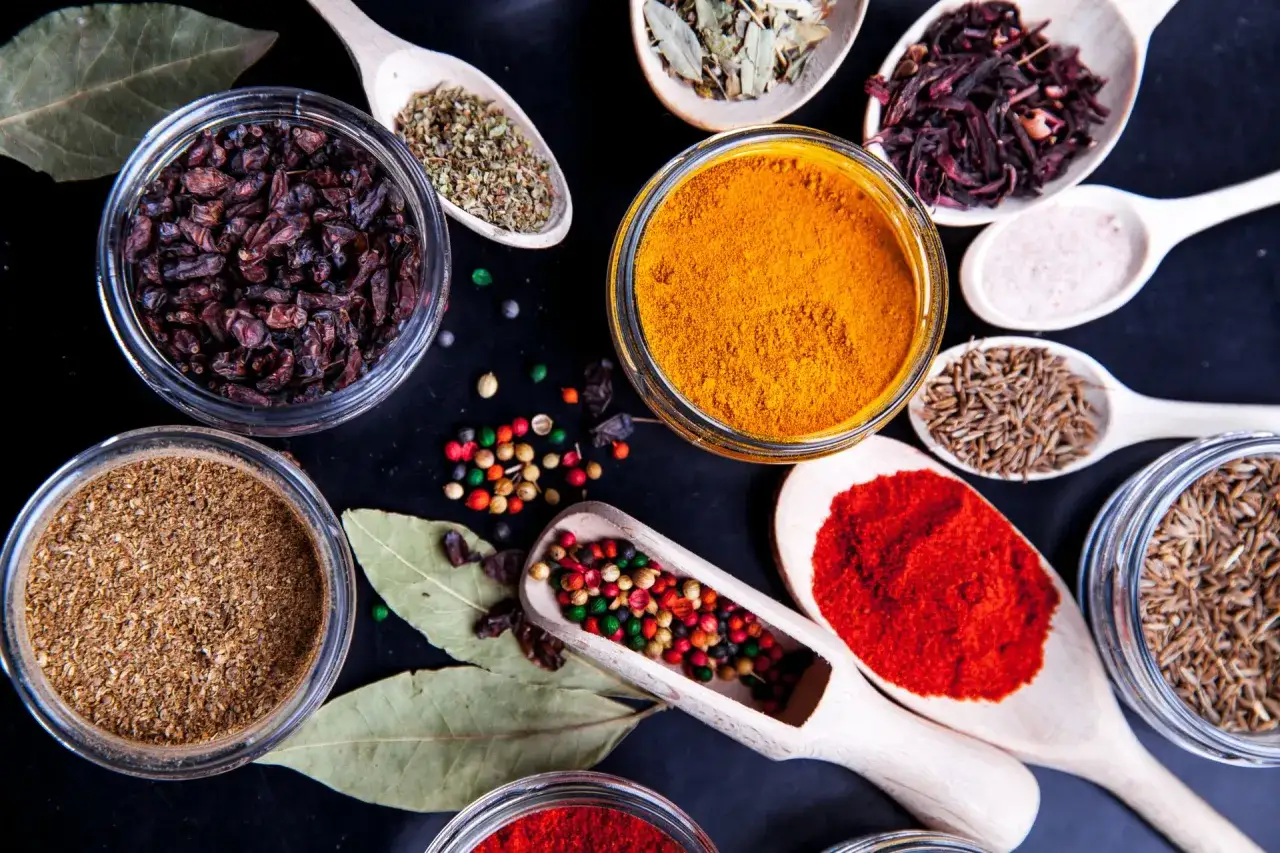 Kolorowe przyprawy, w tym kurkuma, papryka i kmin rzymski, gotowe do przygotowania aromatycznego garam masala.