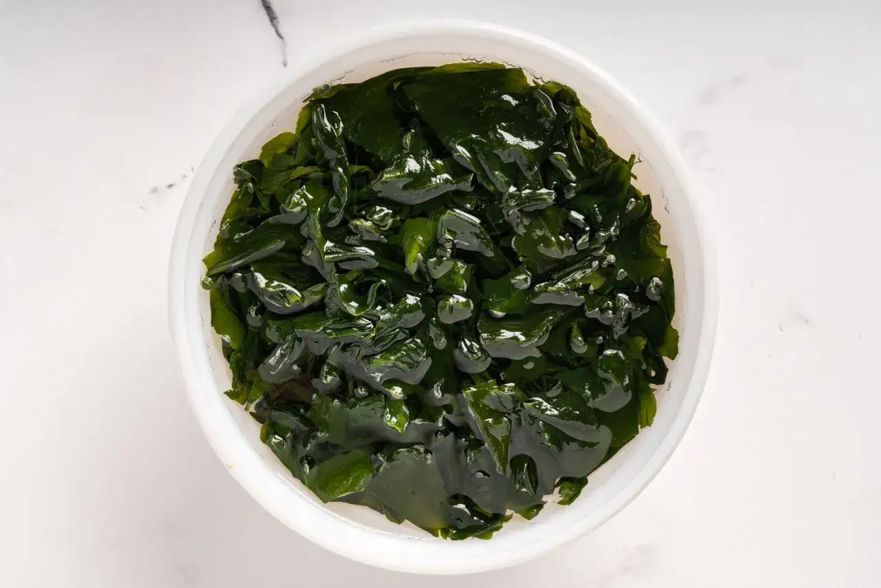 Morska zielenina w misce. Czy to wakame? Tak, to wakame, popularne w kuchni japońskiej.