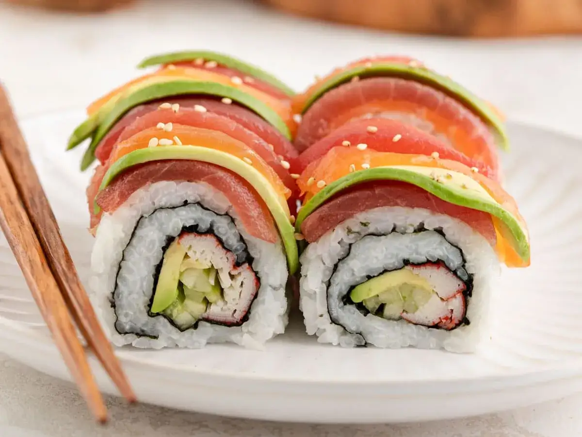 Kolorowe rolki sushi z łososiem, tuńczykiem i awokado. W środku paluszki krabowe i ogórek. Idealne, by dowiedzieć się, co do sushi do środka.