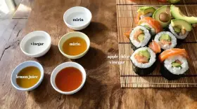 Szukasz alternatywy dla octu ryżowego? Na stole widzisz sushi, jabłkowy ocet, mirin, sok z cytryny i ocet.